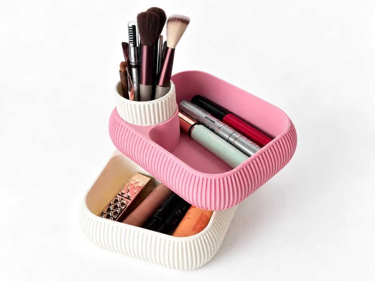 Nōdo two-tier organizer with a pink rotating tray, cream base and central brush holder, shown with everyday accessories.
